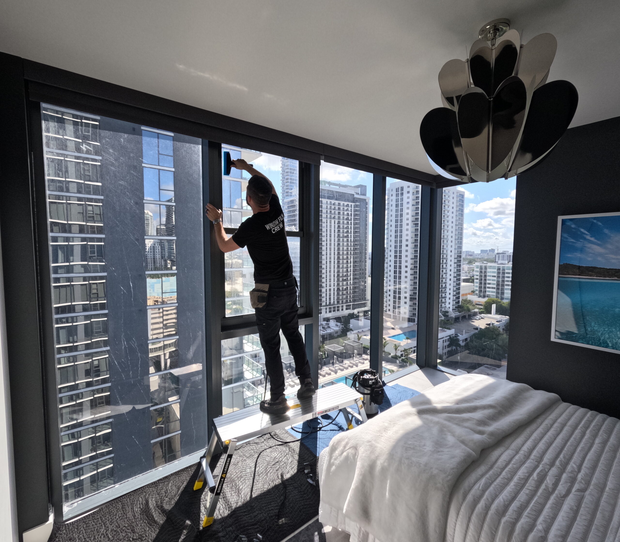 Installer applying 50% ceramic window film in a Miami condo